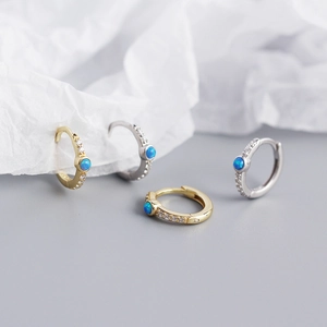 Macro shot of S925 sterling silver hoop earrings with blue opal and sparkling zircon