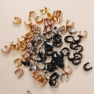 Macro shot of stainless steel pinch bails in gold, silver, rose gold and black for DIY jewelry