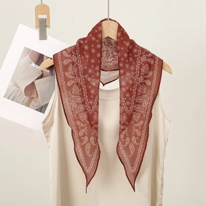 Classic American paisley silk scarf in terracotta red hanging on a wooden hanger
