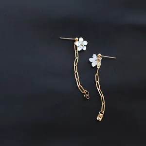 Long gold tassel earrings featuring white shell flower studs and chain drop