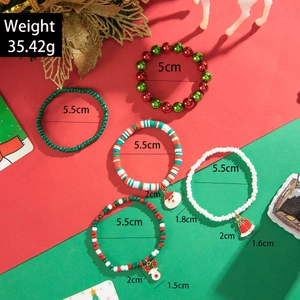 Detailed view of five Christmas themed beaded bracelets with festive charms on red background