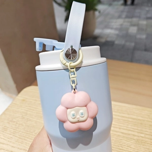 Detail of light blue vacuum insulated coffee cup with flower charm and carry handle
