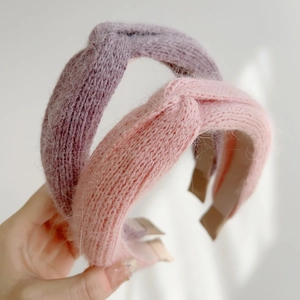 Macro detail of knit twisted headbands in soft mauve and lavender winter yarn texture