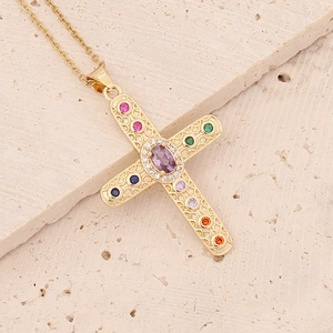 Golden hip hop cross necklace with colorful zircon stones on a beige textured stone base