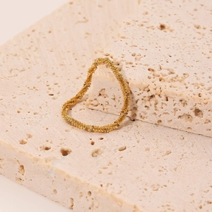 Elegant 18K gold-plated double-loop woven chain heart ring on beige travertine stone