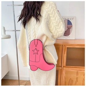 Sac à bandoulière créatif rose en forme de botte de cowboy porté par un modèle