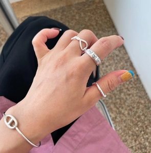 Close-up of minimalist silver 925 rings and chain bracelet with bear motif on hand