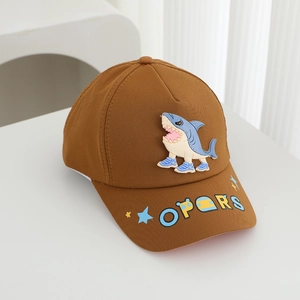 Detail of child baseball cap showing brown cotton fabric and cartoon blue shark embroidery