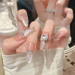 Close-up of cat-eye press-on nails with large floral rhinestone and shimmering accents