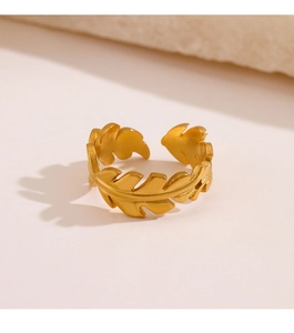 Detailed view of leaf-shaped golden ring with matte finish on a stone pedestal
