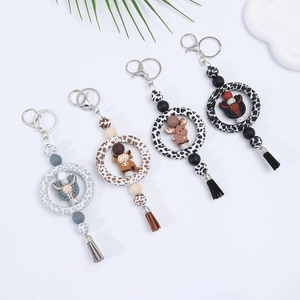 Custom silicone keychain set featuring cartoon highland cow charms and stylish tassels