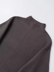 Close-up of the charcoal grey knit texture and mock neck collar of the sweater