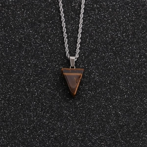 Gros plan du pendentif triangle en œil de tigre avec chaîne torsadée argentée