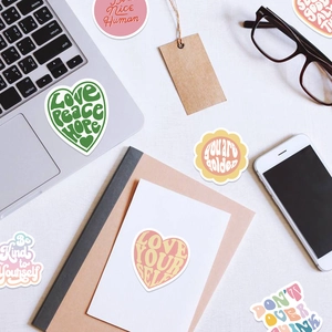 Waterproof Danish pink inspirational stickers spread on a desk near a laptop