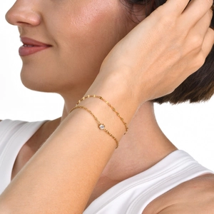 Double-layered gold chain bracelet with white zircon pendant and sequin detail