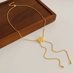 Dettaglio di una collana con ciondolo a fiore placcata in oro con zircone su vassoio