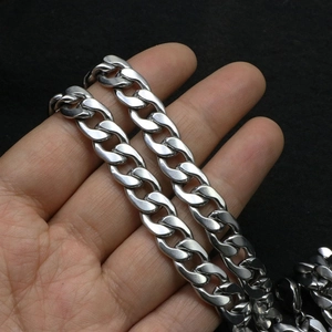 Polished silver stainless steel Cuban link chain necklace held by hand for scale