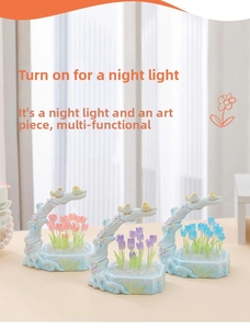 Detail of creative tulip night light with bird figurines on a blue embossed base