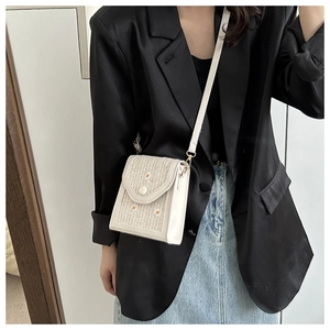 Straw texture crossbody bag with daisy embroidery shown on model with black blazer
