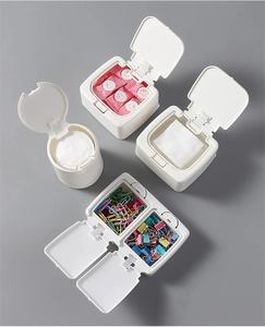 Detailed view of white plastic desk organizers with lids showing cotton pads and stationery