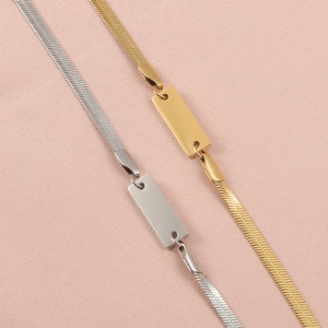 Flat snake chain bracelet in gold and silver with a polished engravable bar tag