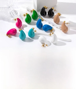 Macro detail of tear-drop enamel earrings in multiple colors with gold titanium finish