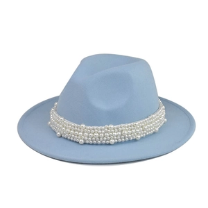 Detalle de sombrero fedora azul claro de ala ancha con elegante adorno de perlas blancas