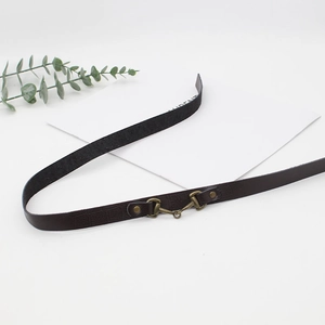 Detail shot of a dark brown textured leather hat band with brass horsebit buckle decoration