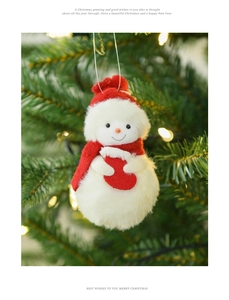 Close-up of plush snowman ornament with red hat hanging on a festive lighted Christmas tree
