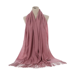 Detail showing soft dusty pink cashmere-like scarf with fringe and woven material label