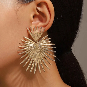 Model wearing large vintage gold sunburst earrings with inlaid turquoise stone