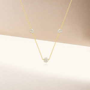 Close-up of S925 silver necklace with sparkling zircon flower pendants in gold finish