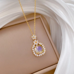 Close-up of golden flower pendant with champagne stone and crystal pave detail
