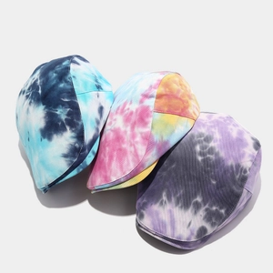 Detailansicht von drei Tie-Dye Schiebermützen in Blau, Regenbogen und Lila Farbtönen