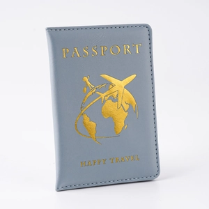 Detalle de funda para pasaporte de cuero PU gris con grabado dorado HAPPY TRAVEL y dibujo