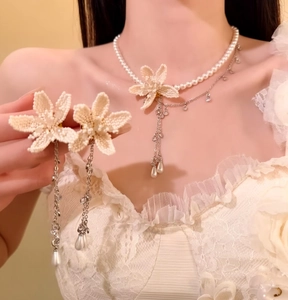 Close-up of elegant French pearl jewelry set with beaded flowers and drop earrings