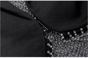 Close-up of black blazer fabric with metal zipper and rhinestone trim detailing