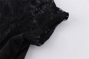 Close-up detail of fine black lace floral mesh pattern on dress sleeve and hemline