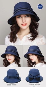Detail view of navy blue woven sun hat with black ribbon bow and foldable wide brim