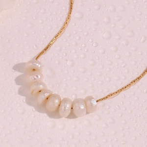 Detalle de cadena de acero oro 18K con siete perlas de agua dulce sobre gotas de agua