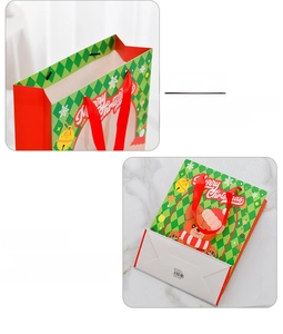 Detail view of the Christmas gift bag showing the red ribbon handle and bottom fold structure