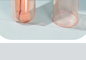Close-up of pink retractable makeup brush cases with soft bristles on a blue background