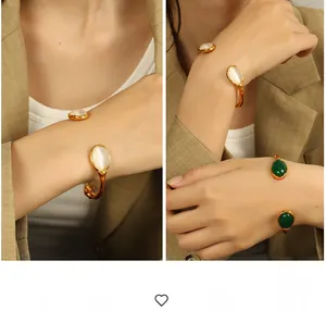 Detailed view of hammered gold cuff with cat eye stone and vintage green agate inlay