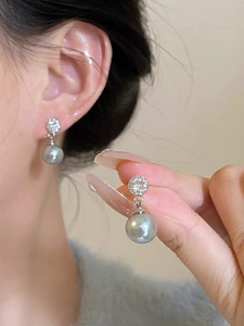 Close-up of elegant grey pearl drop earrings with sparkling pavé cubic zirconia accents