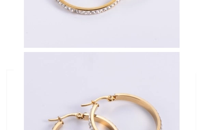 Detailed macro view of gold-plated hoop earrings featuring inlaid white rhinestones