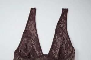 Close-up detail of dark brown lace fabric and deep V-neckline of a backless dress