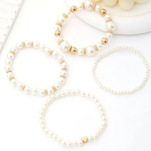 Chic four-piece beaded bracelet set featuring white pearls, gold CCB beads and heart charm