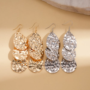 Détail de boucles d'oreilles en cascade avec texture martelée en tons or et argent