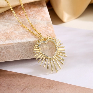 Detailed close-up of a gold heart pendant with colorful crystals on a textured background