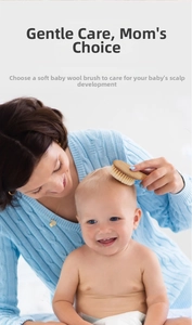 Close-up of mother gently brushing newborn baby hair with soft goat wool brush